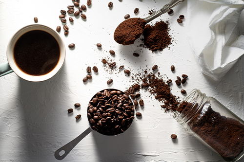 دانه قهوه، پودر قهوه و یک فنجان قهوه